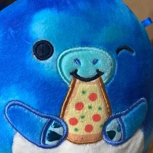 Small Squishmallow dragon with pizza